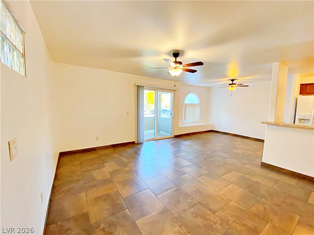 3145 East Flamingo Road, Unit 1128 Las Vegas, NV 89121 - Photo 4 of 19 Bright, open-concept living area with large format tile flooring and outdoor access.