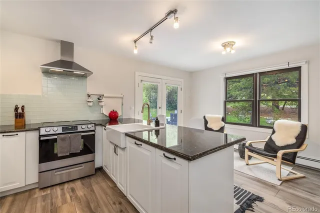 a kitchen with a stove a sink and chairs