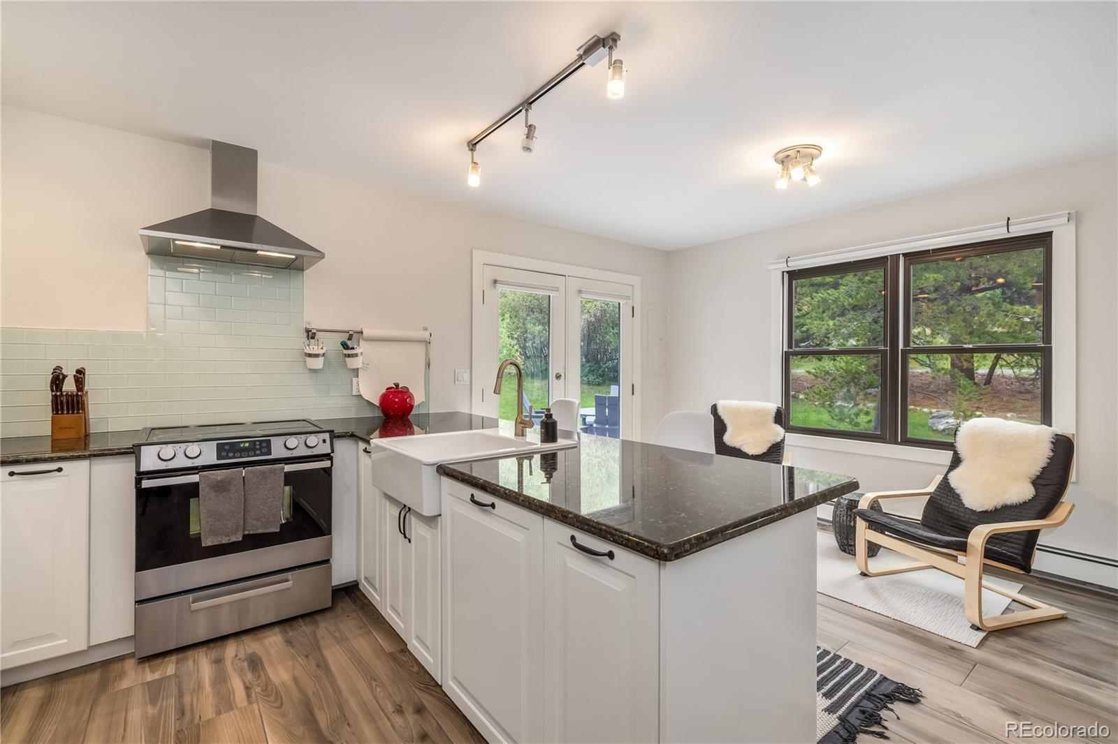 196 Wellington Road Breckenridge, CO 80424 - Photo 6 of 45 a kitchen with a stove a sink and chairs
