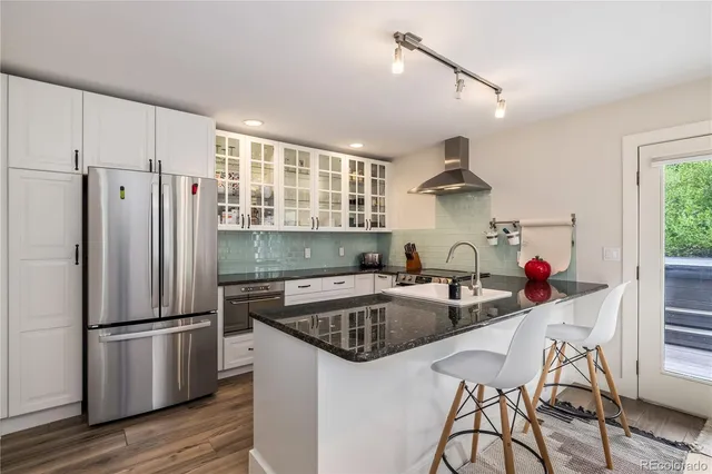 a kitchen that has a sink cabinets and stainless steel appliances