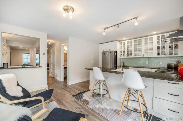 a kitchen with granite countertop a table and chairs in it