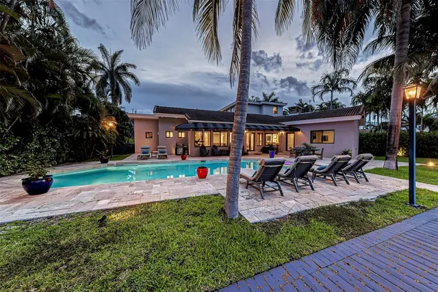 a kitchen with kitchen island granite countertop a sink cabinets and stainless steel appliances