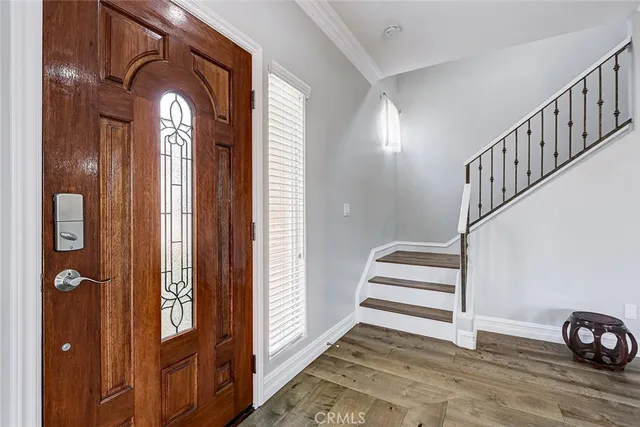 a view of a hallway with wooden floor and staircase