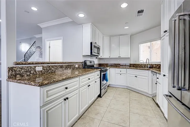 a kitchen with granite countertop white cabinets and white appliances
