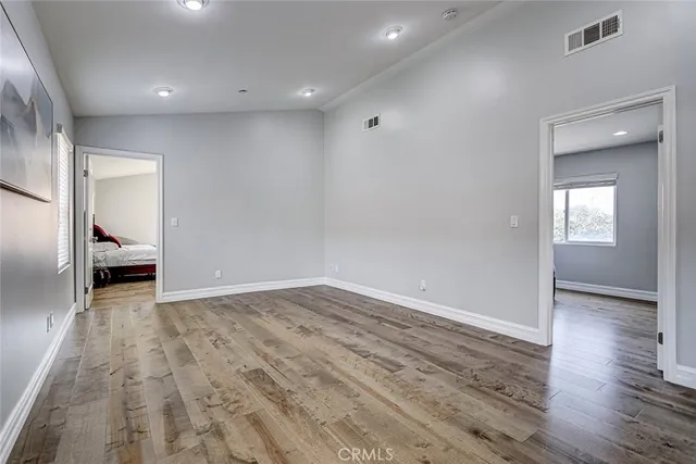 a view of empty room with wooden floor