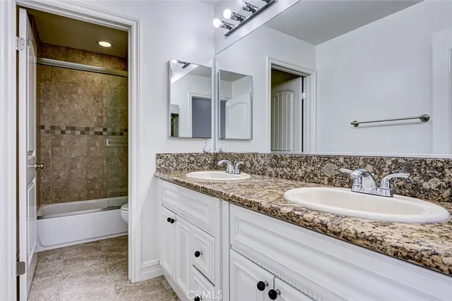 a bathroom with a granite countertop sink mirror and shower