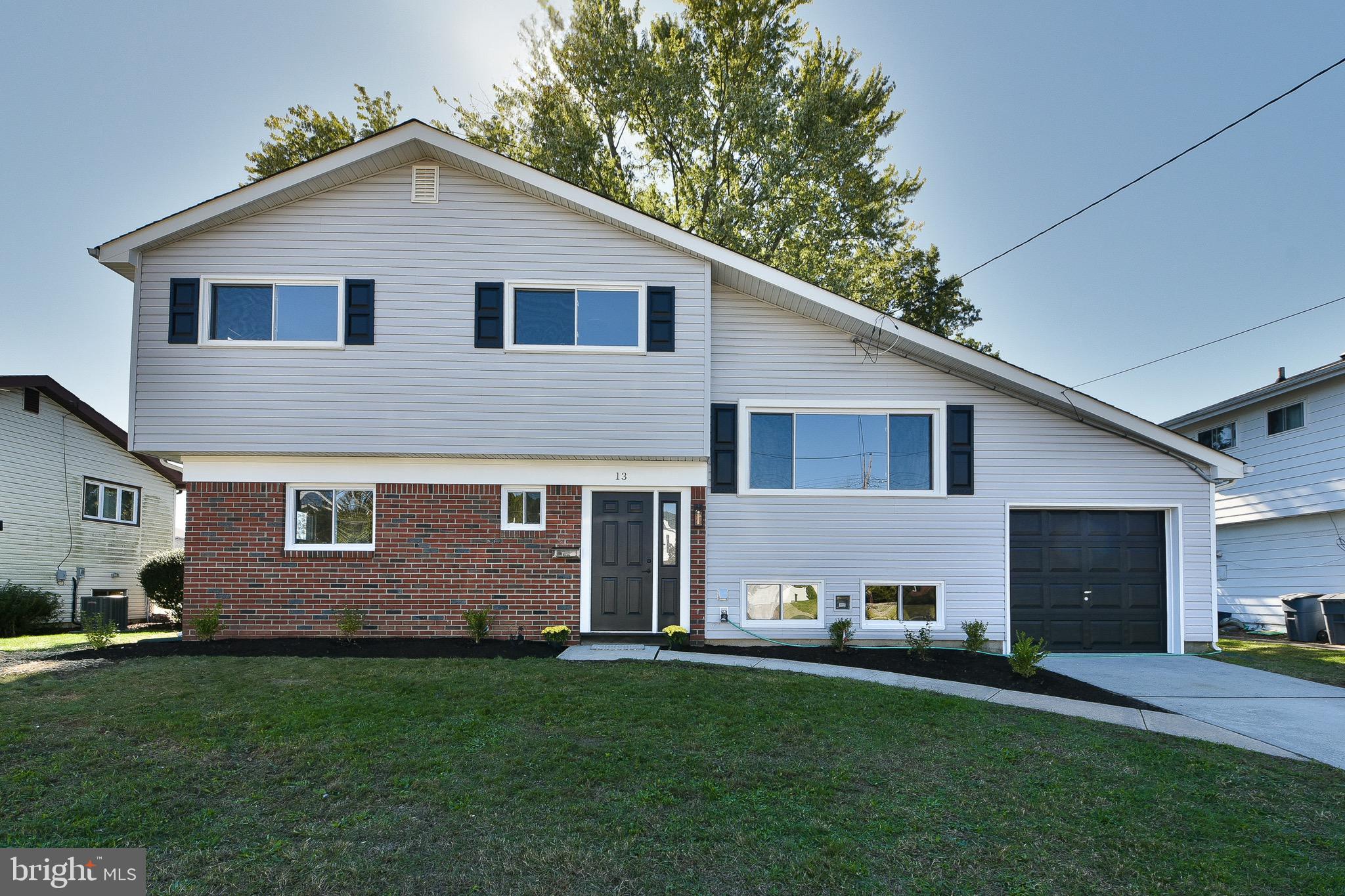 13 Sycamore Way Hamilton, NJ 08690 - Photo 3 of 37 a view of a yard in front of a house with large windows