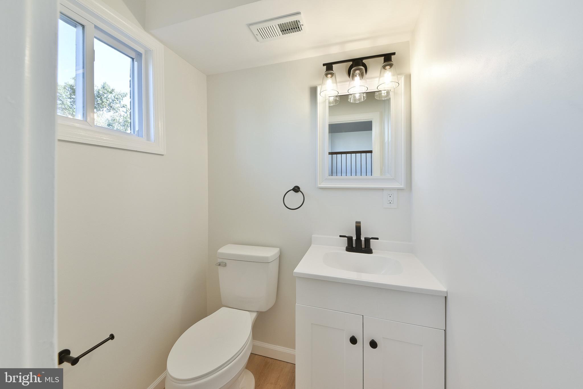 13 Sycamore Way Hamilton, NJ 08690 - Photo 8 of 37 a bathroom with a toilet a sink a mirror and vanity