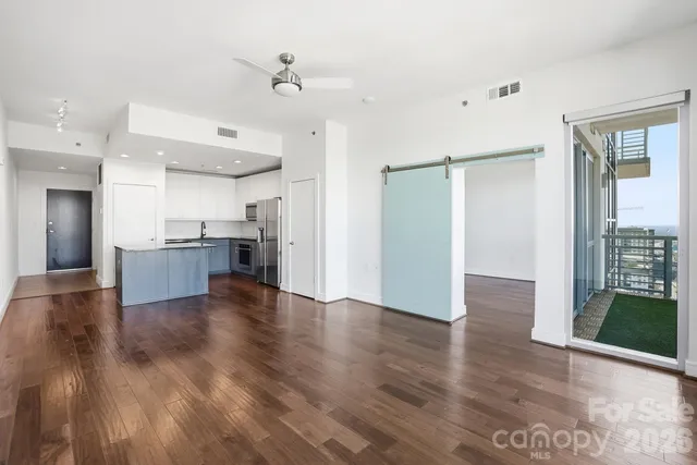 a view of an empty room with wooden floor