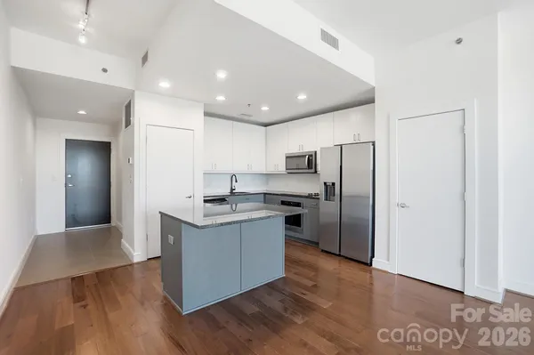 a kitchen with stainless steel appliances granite countertop a sink and a refrigerator
