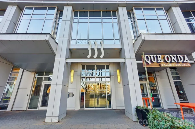 a kitchen with stainless steel appliances granite countertop a refrigerator a sink dishwasher a stove and a wooden floors