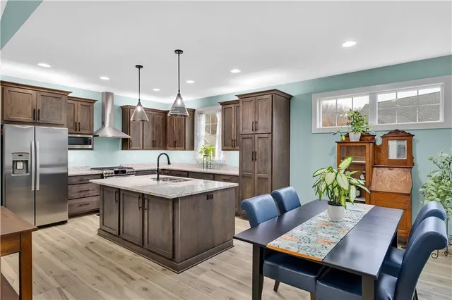 a kitchen with stainless steel appliances granite countertop a sink stove and refrigerator