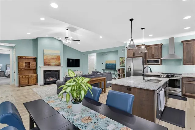 a large kitchen with kitchen island a stove a sink a dining table and chairs