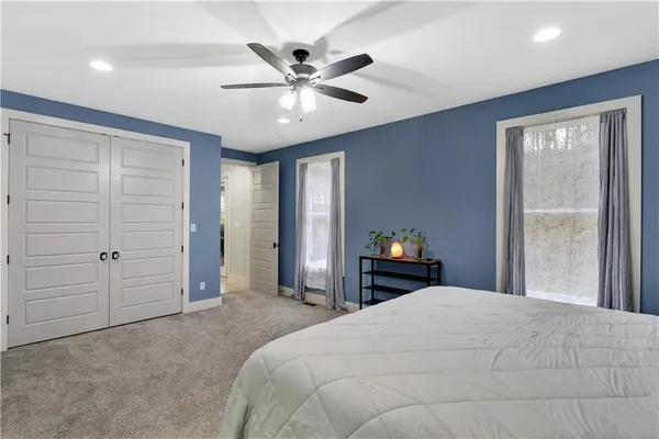 a bedroom with a large bed and a chandelier