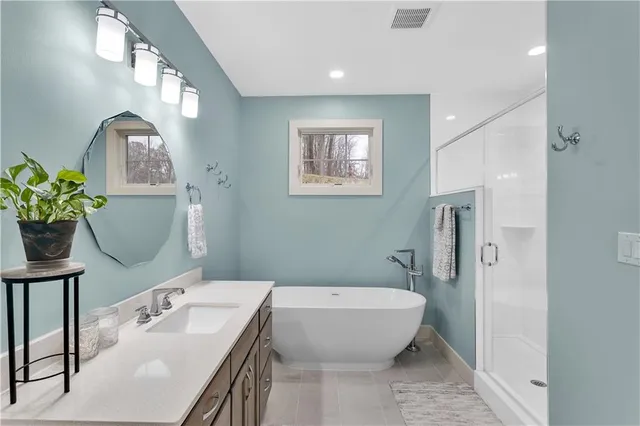 a bathroom with a granite countertop sink a toilet a mirror and shower