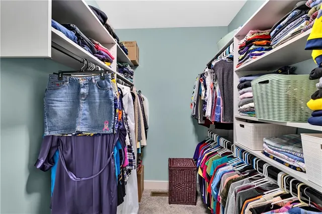 a view of walk in closet with clothes and shoes