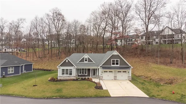 a view of a big house with a big yard and large trees