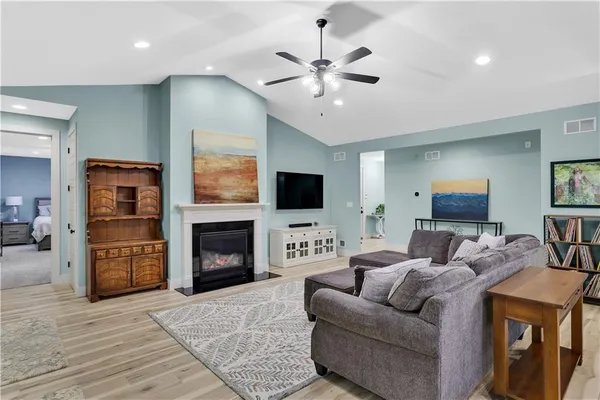 a living room with furniture a fireplace and a flat screen tv