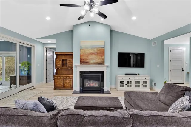 a living room with furniture a flat screen tv and a fireplace