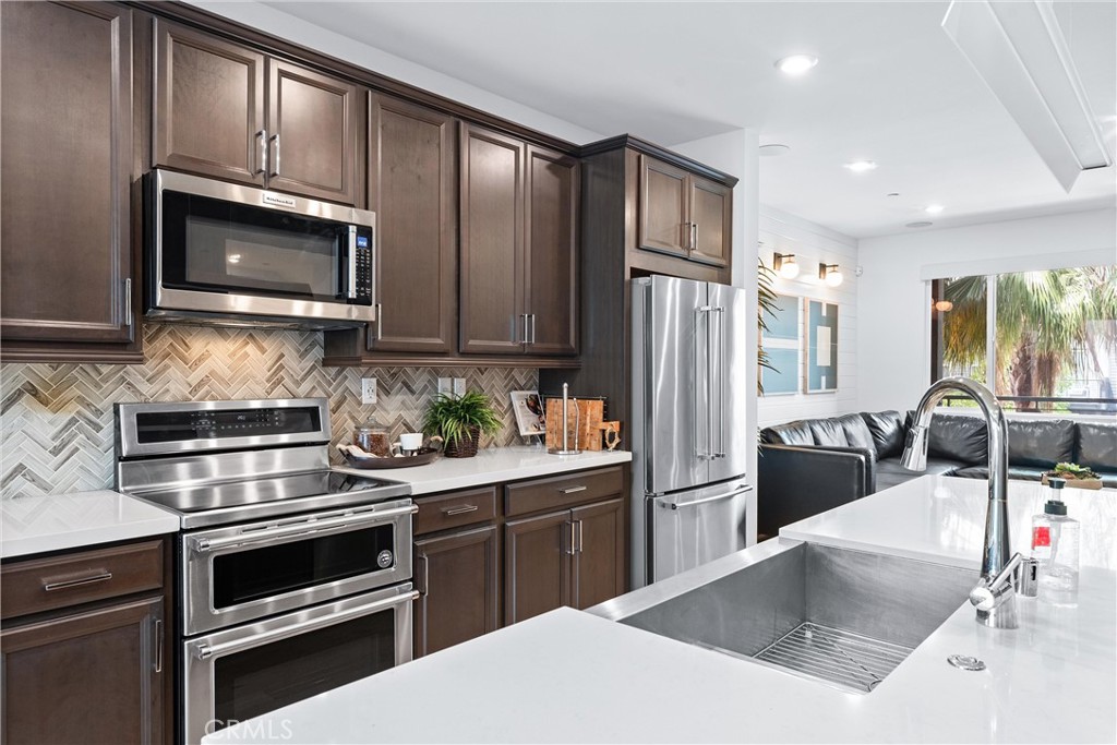 134 Citysquare Irvine, CA 92614 - Photo 12 of 32 a kitchen with granite countertop a refrigerator stove and microwave