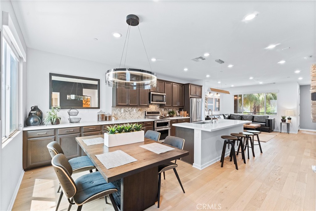 134 Citysquare Irvine, CA 92614 - Photo 15 of 32 a kitchen with a dining table chairs stove and white cabinets