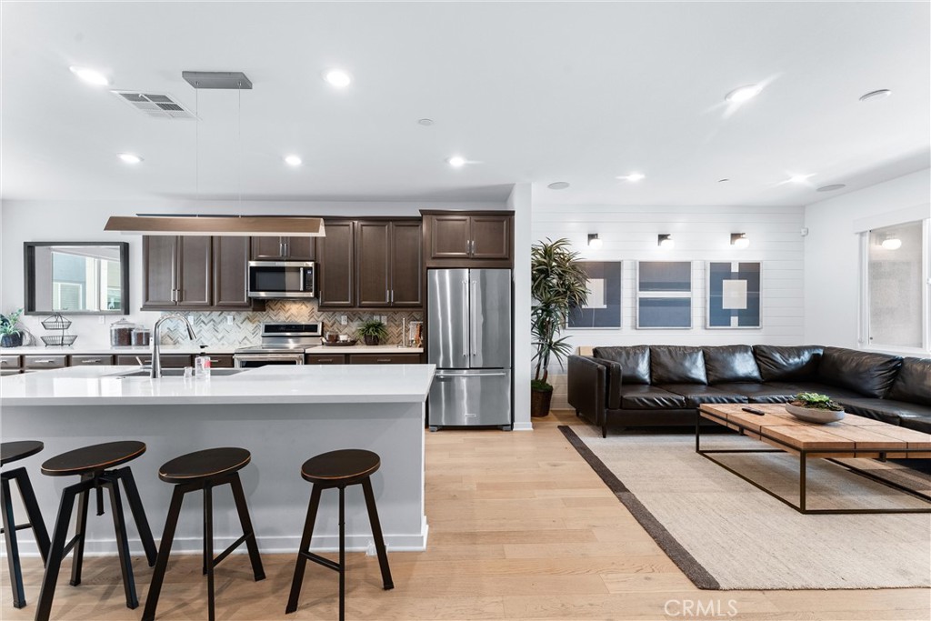 134 Citysquare Irvine, CA 92614 - Photo 10 of 32 a kitchen with stainless steel appliances granite countertop a refrigerator a stove a sink a dining table and chairs