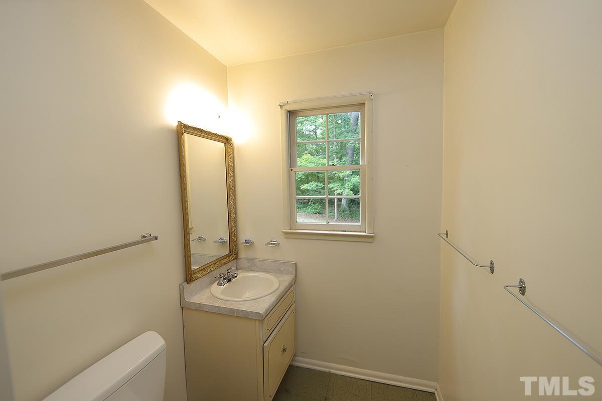1337 Clermont Road Durham, NC 27713 - Photo 6 of 16 a bathroom with a sink a toilet and mirror