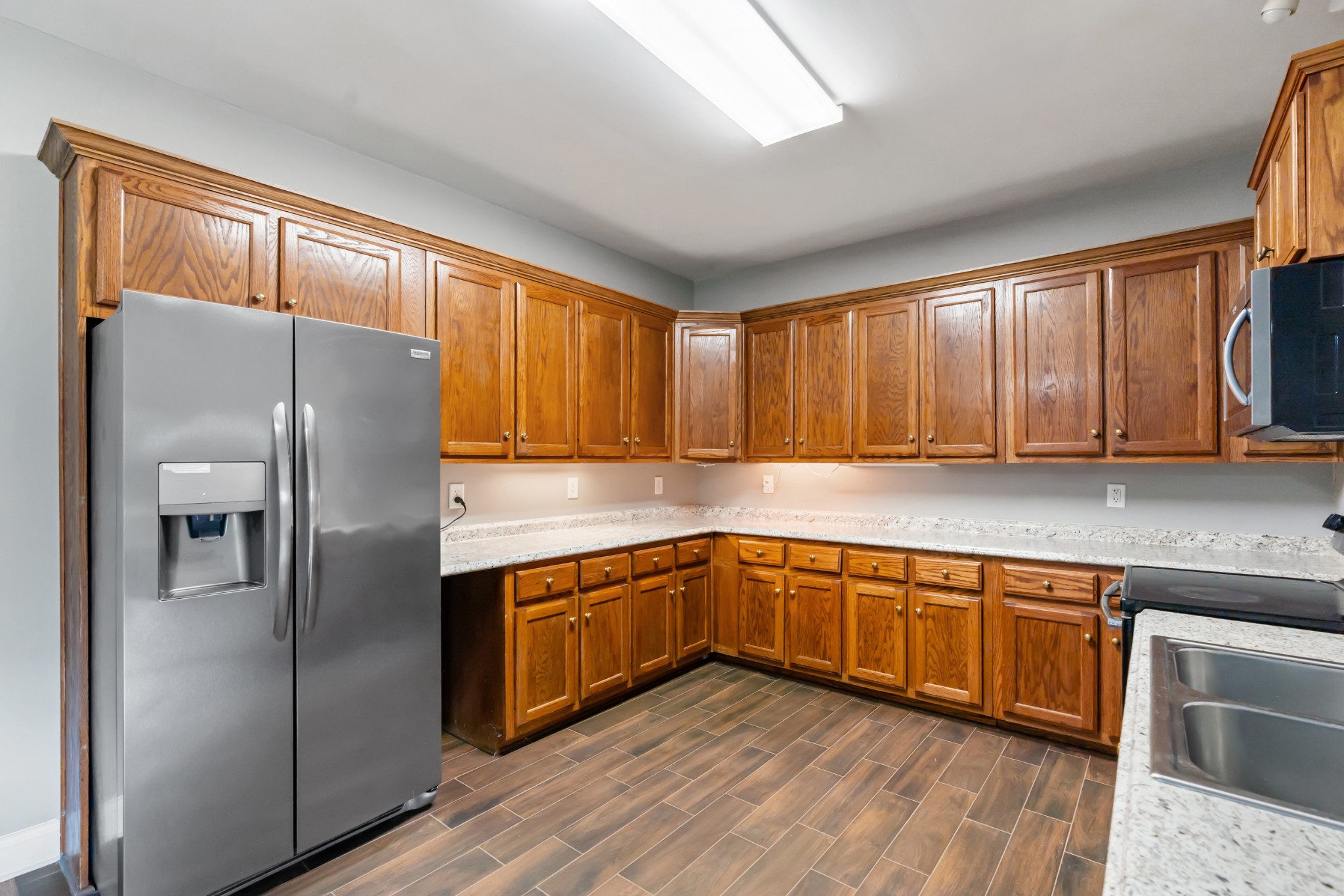 4602 Washington Road Springfield, TN 37172 - Photo 14 of 63 a kitchen with stainless steel appliances granite countertop a refrigerator a sink dishwasher a stove with wooden cabinets and floor