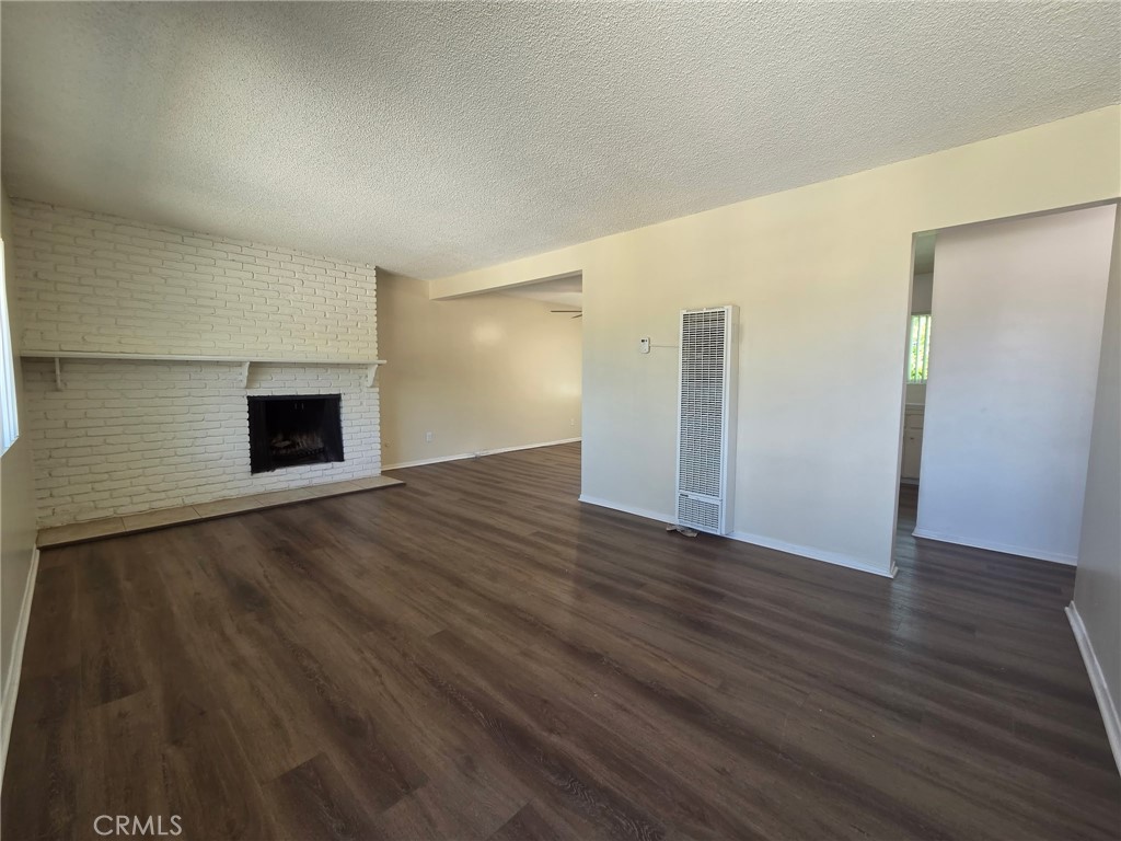 144 West Baseline Road, Unit 8 San Dimas, CA 91773 - Photo 3 of 9 an empty room with wooden floor and fireplace