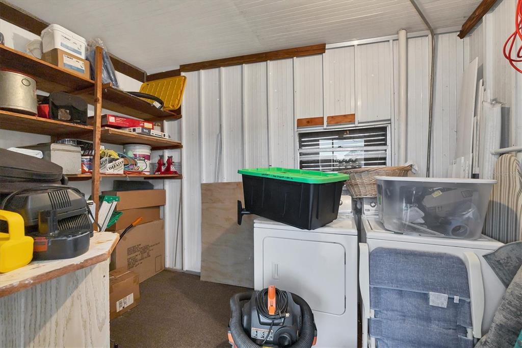 1891 Englewood Road, Unit 1 Englewood, FL 34223 - Photo 27 of 46 a kitchen with stainless steel appliances kitchen island granite countertop a refrigerator and a stove top oven