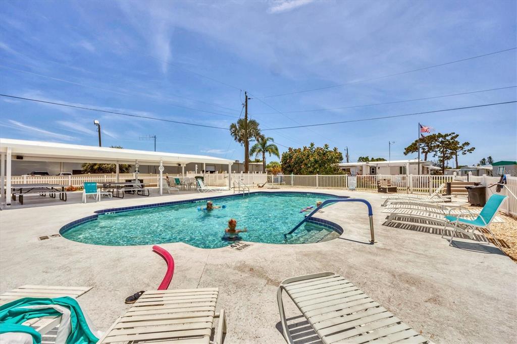 1891 Englewood Road, Unit 1 Englewood, FL 34223 - Photo 38 of 46 a swimming pool with outdoor seating and yard