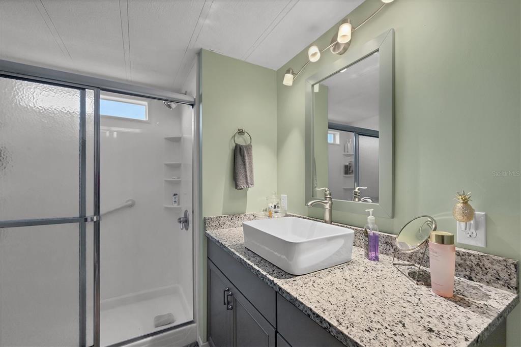 1891 Englewood Road, Unit 1 Englewood, FL 34223 - Photo 4 of 46 a bathroom with a granite countertop sink and a mirror