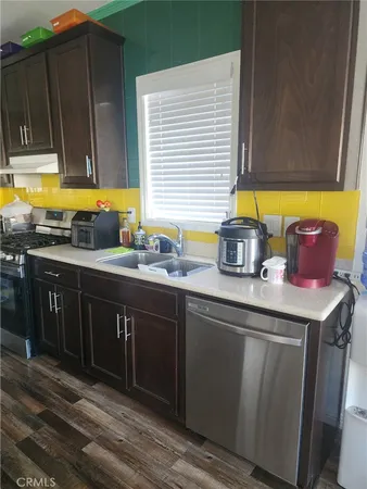 a kitchen with stainless steel appliances a sink stove and cabinets