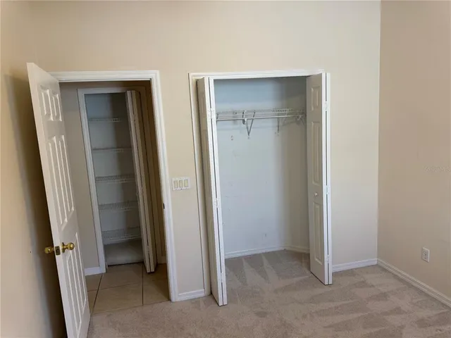 a view of an empty room with closet and wooden floor