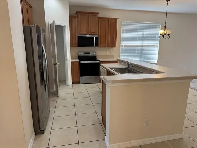 a kitchen with stainless steel appliances a refrigerator sink and microwave