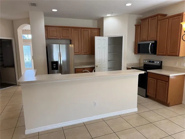 a kitchen with stainless steel appliances a refrigerator sink and microwave