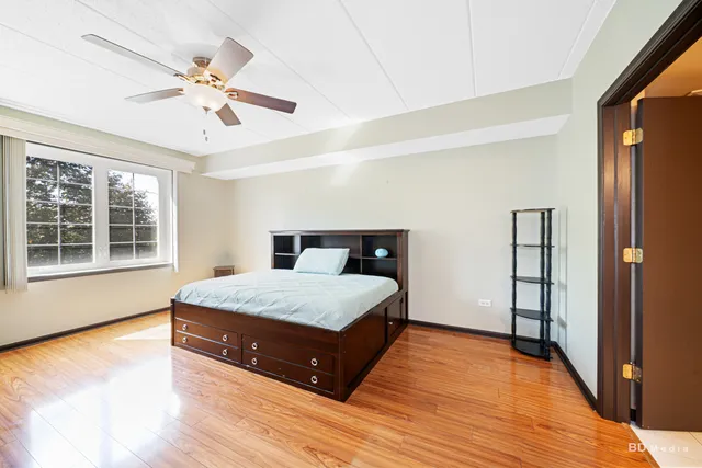 a spacious bedroom with a bed and wooden floor