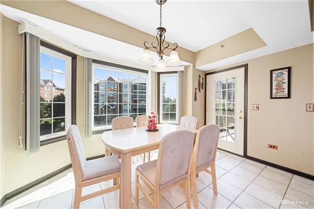 a dining room with furniture a chandelier and wooden floor