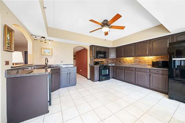 a kitchen with stainless steel appliances kitchen island granite countertop a sink counter space and cabinets