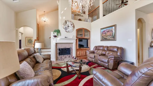a living room with furniture kitchen view and a chandelier