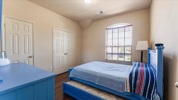 a bedroom with a bed and a large mirror on the dresser