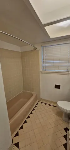 a view of an empty room with a chandelier fan