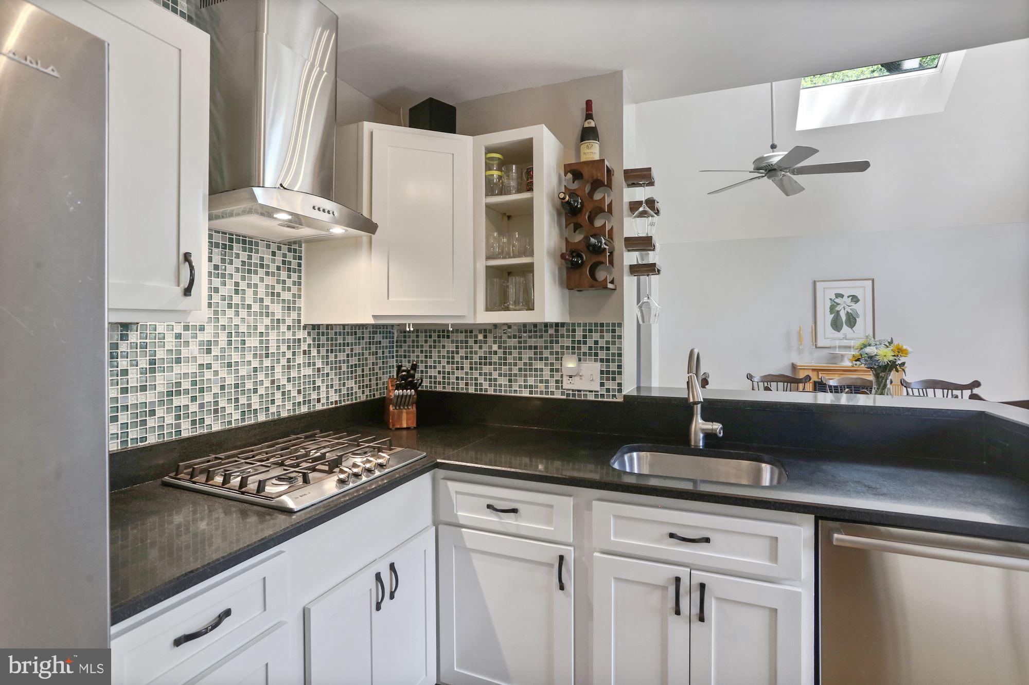 8405 Fort Hunt Road Alexandria, VA 22308 - Photo 10 of 35 Glass tile backsplash, white cabinets, sunny space