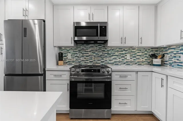 a kitchen with stainless steel appliances a stove microwave and refrigerator