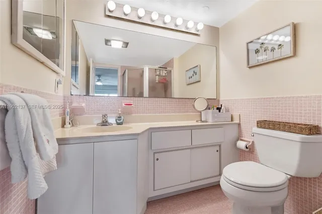 a bathroom with a granite countertop toilet sink and mirror
