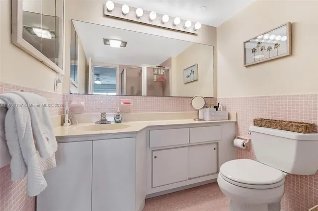 a bathroom with a granite countertop toilet sink and mirror
