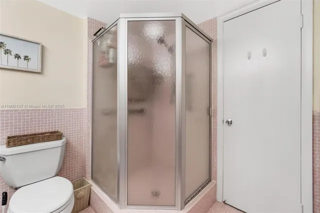 a bathroom with a toilet and a shower