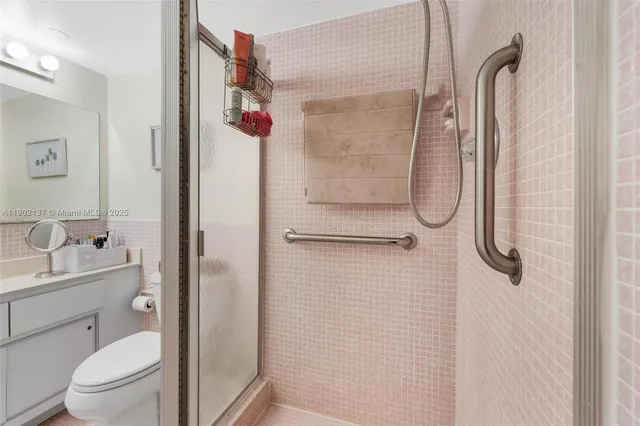 a bathroom with a shower sink vanity mirror and toilet