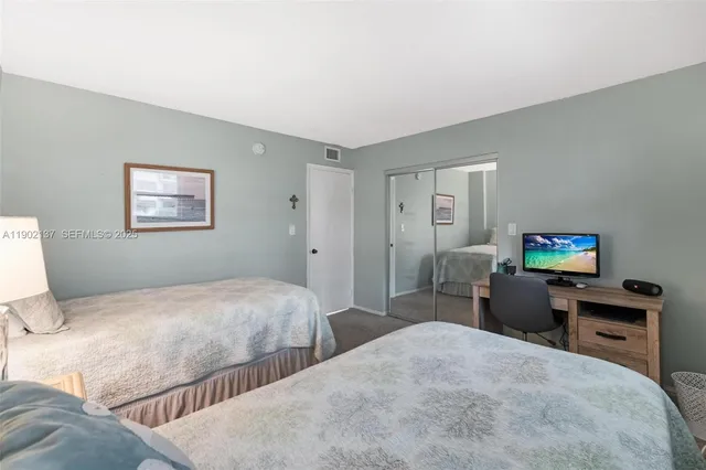 a bedroom with two beds and a desk