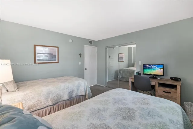 a bedroom with two beds and a desk